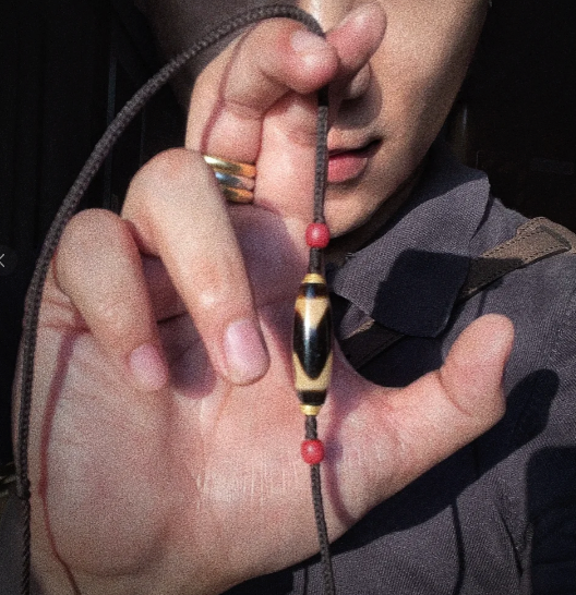 Dzi bead presented as wearable Himalayan art with symbolic agate presence